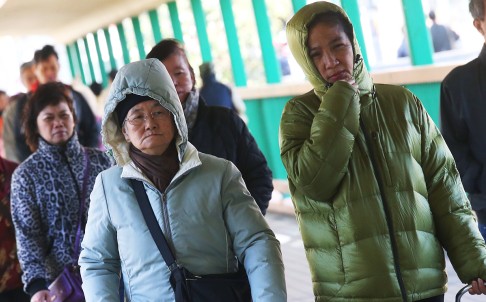 People wear thick clothes under the cold weather in Hung Hom. Photo: K.Y. Cheng