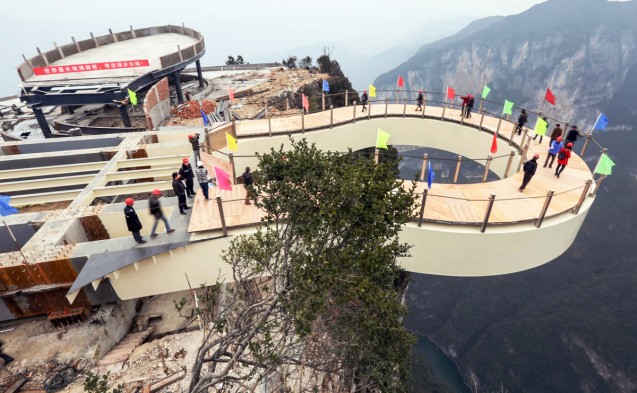 Walking on air - Workers walk along the world’s first steel-free cantilever bridge. It was built 718 metres above ground level in Longgang near Chongqing. It is a tourist facility to highlight the spectacular scenery in the area, which is close to the famous Three Gorges along the Yangtze River. The bridge, made only of glass, is set to open to tourists in May. However, some visitors might have second thoughts about walking on the bridge given that it has no support beneath it. Photo: Xinhua