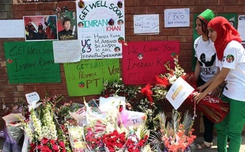 Supporters of Pakistani politician and former cricketer Imran Khan, place flowers outside a hospital where Khan is admitted in Lahore on Wednesday. Photo: AFP