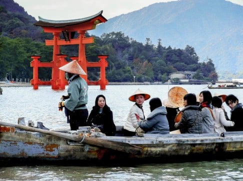 Tourists pass the Great Torii Gate near Miyajima Island.