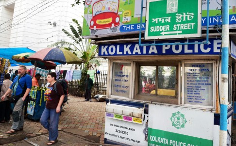 Foreign tourists (left) walk past a police assistance booth on Sudder Street. Photo: AFP